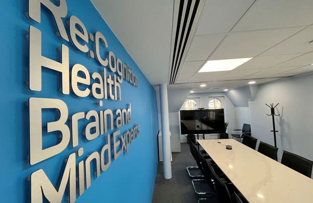 Reception meeting room with brain and mind expert signage on a blue wall at a memory & brain health centre
